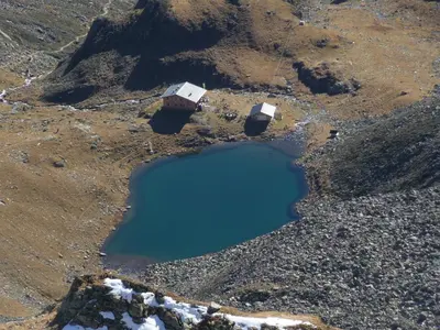 an aerial view of a mountain with a blue lake at Apartments Ferdigg in San Lorenzo di Sebato