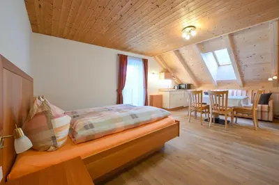 a bedroom with a bed with a wooden ceiling at Apartments Ferdigg in San Lorenzo di Sebato