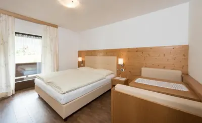 a bedroom with a large bed and a window at Apartments La Rives in Santa Cristina in Val Gardena