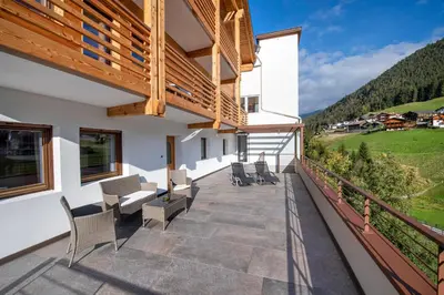 a balcony of a house with chairs and a view at Apartments La Rives in Santa Cristina in Val Gardena