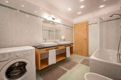 a bathroom with a washing machine and a sink at Apartments La Rives in Santa Cristina in Val Gardena
