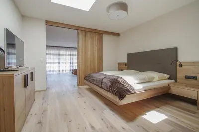 a bedroom with a large bed and a television at Apartment Hotel Christine in Avelengo