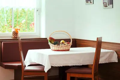 a basket of fruit on a table with two chairs at Apartment in Dolomites with Pool Access in Naz-Sciaves