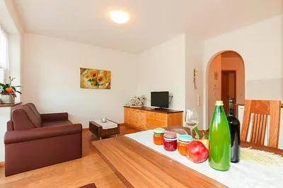 a living room with a table with fruit and wine bottles at Apartment in Dolomites with Pool Access in Naz-Sciaves