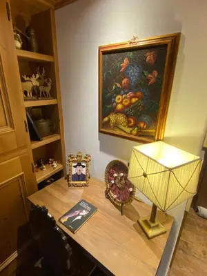 a desk with a painting and a lamp on it at Incantevole monolocale in centro a Cortina. in Cortina dʼAmpezzo