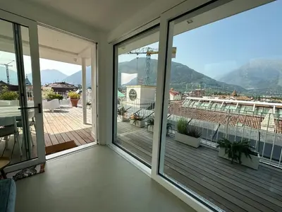 a balcony with sliding glass doors and a view of the mountains at Merano Absolute View in Merano