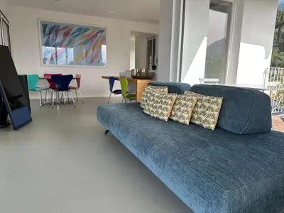 a blue couch in a living room with a table and chairs at Merano Absolute View in Merano