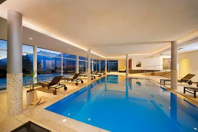 a large swimming pool in a house with windows at Garni Kleefeld in Schenna