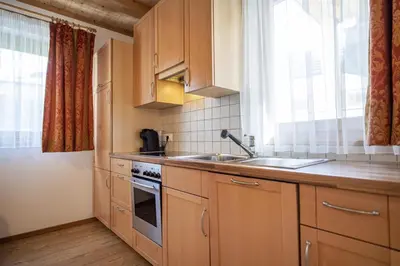 a kitchen with wooden cabinets and a sink and a window at Apartments Bea in Ortisei