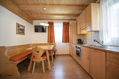a kitchen with a table and a dining room at Apartments Bea in Ortisei