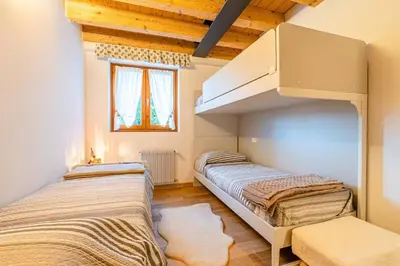 two beds in a room with wooden ceilings at Charming Civetta in Alleghe
