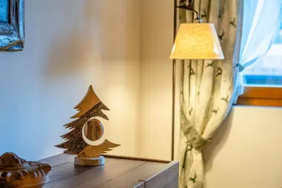 a lamp and a wooden christmas tree on a table at Charming Civetta in Alleghe
