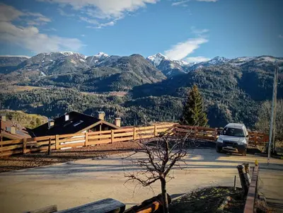 a car parked in a parking lot with mountains in the background at Pozza Appartamenti in Carano