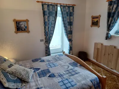 a bedroom with a bed with a quilt on it at Appartamento Valmaor in Predazzo