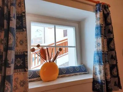 a window with an orange vase sitting on a window sill at Appartamento Valmaor in Predazzo