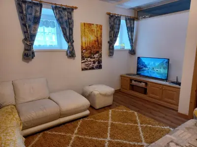 a living room with a couch and a flat screen tv at Appartamento Valmaor in Predazzo
