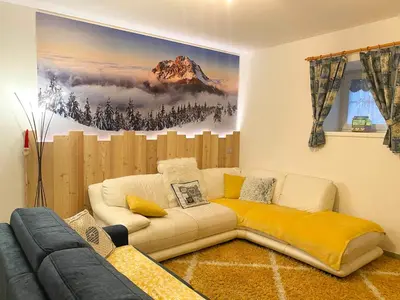 a living room with a couch and a painting on the wall at Appartamento Valmaor in Predazzo