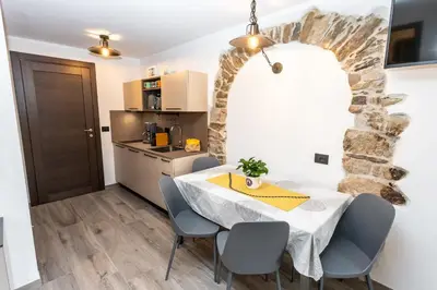 a kitchen and a dining room with a table and chairs at Agritur E-Cinque in Salorno sulla Strada del Vino