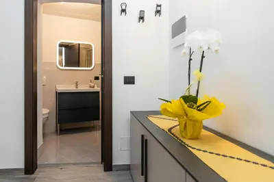 a bathroom with a yellow vase with flowers on a counter at Agritur E-Cinque in Salorno sulla Strada del Vino