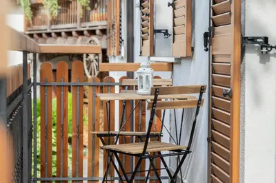a wooden chair sitting on a balcony with a table at Agritur E-Cinque in Salorno sulla Strada del Vino