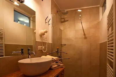 a bathroom with a sink and a shower at Gasthaus Babsi in Soprabolzano