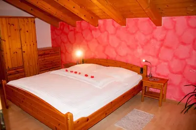 a bedroom with a large bed with a pink wall at Gastreinhof in Meltina