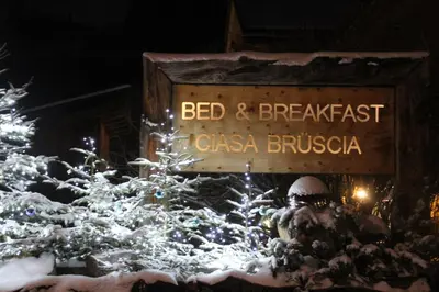 a sign for a bed and breakfast with christmas trees at B&B Ciasa Brüscia in San Vigilio Di Marebbe