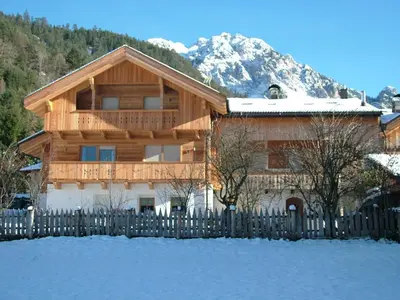 a wooden house with a fence in the snow at B&B Ciasa Brüscia in San Vigilio Di Marebbe