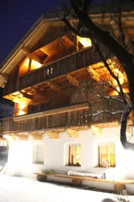 a house in the snow at night at B&B Ciasa Brüscia in San Vigilio Di Marebbe
