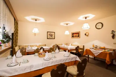 a restaurant with tables and chairs and a clock at Ciasa Iris in Colfosco