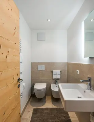 a bathroom with a toilet and a sink at Ciasa Agreiter in La Villa