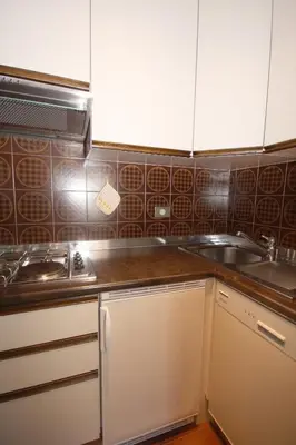 a kitchen with white cabinets and a sink at Apartments Residence Alta Badia in Colfosco