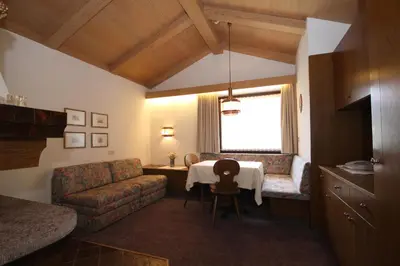 a living room with a table and a couch at Apartments Residence Alta Badia in Colfosco