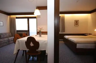 a hotel room with a table and a bed at Apartments Residence Alta Badia in Colfosco