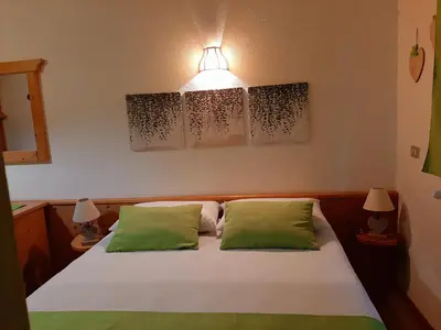 a bedroom with a bed with two green pillows at Casa AQ27 sulle piste da sci in Falcade