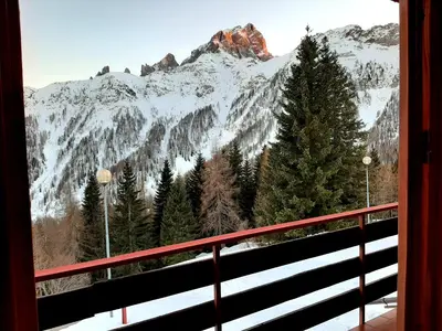 a view of a snow covered mountain from a balcony at Casa AQ27 sulle piste da sci in Falcade