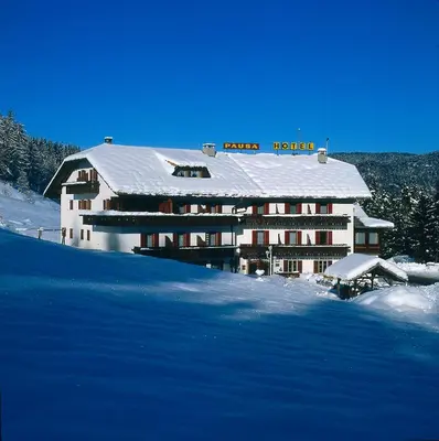 a restaurant with tables and chairs with pink tablecloths at Hotel Pausa in Montagna