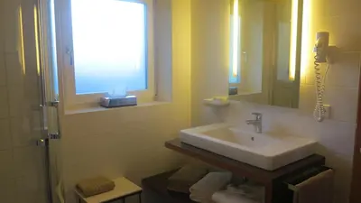 a bathroom with a sink and a window at Apparthotel Gartenresidence Nalserhof in Nalles