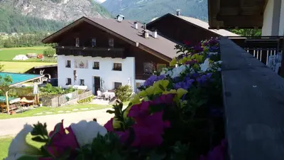 a house with a bunch of flowers in front of it at Lahnerhof in Campo Tures
