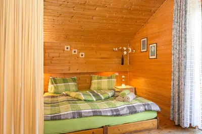 a bedroom with a bed in a wooden wall at Lahnerhof in Campo Tures