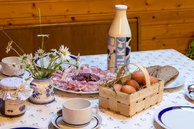 a table with a basket of eggs and a bottle of milk at Lahnerhof in Campo Tures