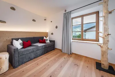 a living room with a couch and a window at Sigmundhof in Bressanone