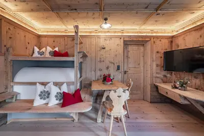 a room with a bunk bed and a tv at Sigmundhof in Bressanone