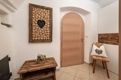 a hallway with a wooden door and a wooden chair at Sigmundhof in Bressanone