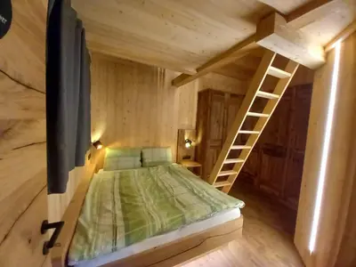 a small bedroom with a bed and a ladder at Chalet Silvesterhütte in Seiser Alm