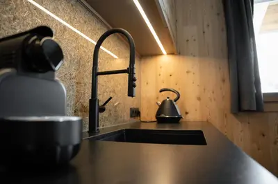 a kitchen sink with a tea kettle on the counter at Chalet Silvesterhütte in Seiser Alm