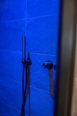 a blue tiled bathroom with a blue shower stall at Chalet Silvesterhütte in Seiser Alm
