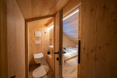 a small room with a bed and a bathroom at Chalet Silvesterhütte in Seiser Alm