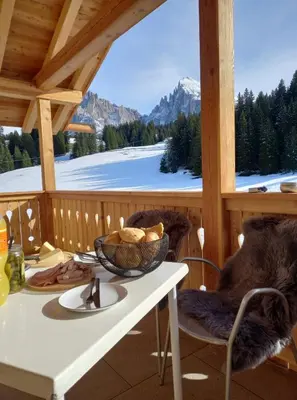 a table with a bowl of food on a porch at Chalet Silvesterhütte in Seiser Alm