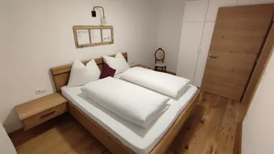 a bed with white sheets and pillows in a room at Residence Maximilian in Vipiteno